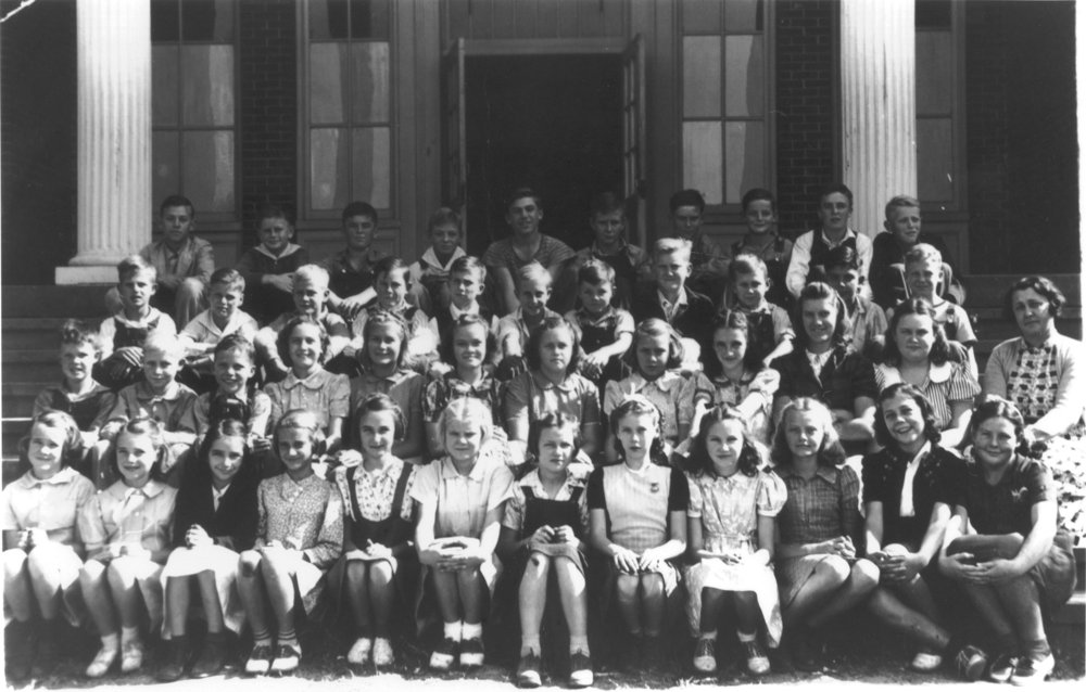 Black-and-white group photograph from the Class of ’46 archive, with students arranged on building steps.