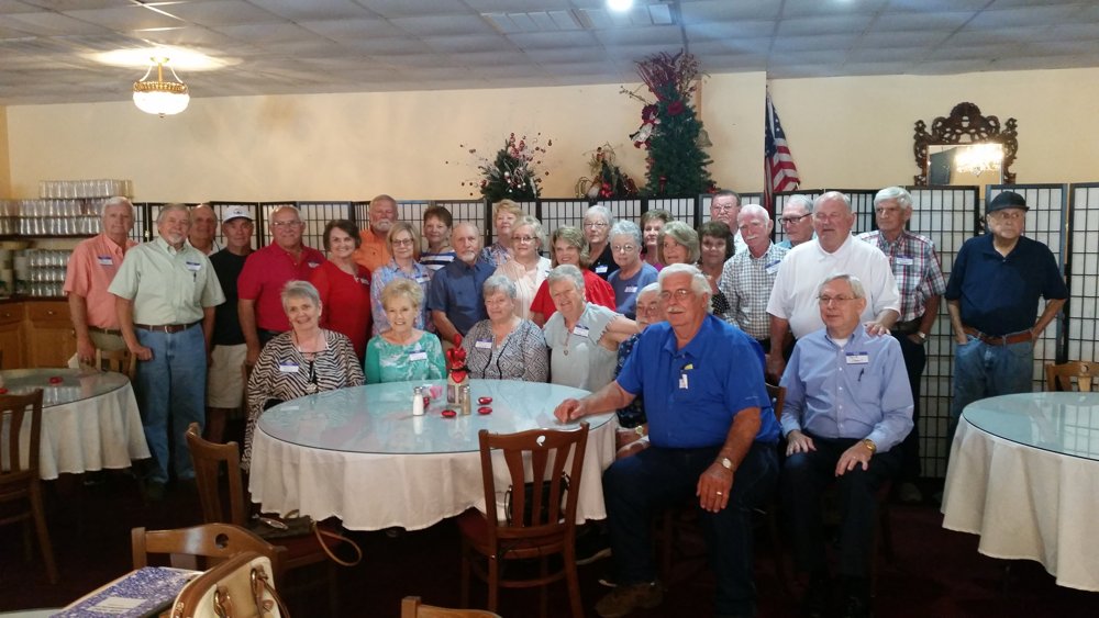 Class of 1967 alumni gathered around tables for a group photograph at their 55th reunion.
